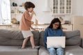 Stressed young woman work at home on laptop tired stressed of hyperactive disobedient little kid Royalty Free Stock Photo