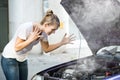 Woman Looking Under The Hood Of Breakdown Car