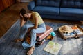 Frustrated young woman sitting on travel suitcase with clothes excess Royalty Free Stock Photo