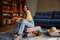 Frustrated young woman sitting on travel suitcase with clothes excess Royalty Free Stock Photo