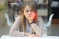 Frustrated young woman suffering from toothache in a mall cafe after visiting a dentist. Beautiful lady Royalty Free Stock Photo