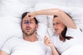 Woman Trying To Stop Man`s Snoring With Clothespin Royalty Free Stock Photo