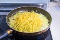 Fry pan with raw spaghetti pasta cooking on boiled water Royalty Free Stock Photo