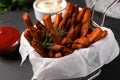 Frying basket with sweet potato fries and sauces on black table, closeup Royalty Free Stock Photo