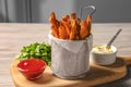 Frying basket with sweet potato fries, sauces and parsley on table Royalty Free Stock Photo