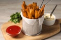 Frying basket with sweet potato fries, sauces and parsley on table, closeup Royalty Free Stock Photo