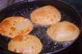 frying chapati(poori) on frying pan, boiling oil in frying pan with dark background, kitchen concept, selective focus Royalty Free Stock Photo
