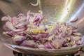 Frying chopped onions, shallots and garlic in a wok.