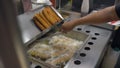 Frying Churros in deep oil in Churreria. Traditional Mexican Dough Pastry Snack