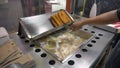 Frying Churros in deep oil in Churreria. Traditional Mexican Dough Pastry Snack