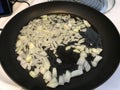 Frying fresh onion on the stove in frying pan
