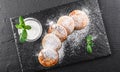 Frying homemade cottage cheese pancakes syrniki with powdered sugar, sour cream.