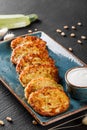 Frying homemade pancakes from zucchini with sour cream in plate on dark stone background. Clean eating. Healthy breakfast.Top view Royalty Free Stock Photo