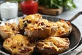 Frying pan of baked potatoes with cheese and bacon on table Royalty Free Stock Photo