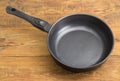 Frying pan with ceramic non-stick coating on wooden surface Royalty Free Stock Photo