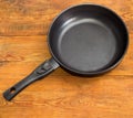 Frying pan with ceramic non-stick coating on wooden surface Royalty Free Stock Photo