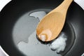 Frying pan with coconut oil and wooden spoon. Healthy cooking Royalty Free Stock Photo