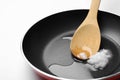 Frying pan with coconut oil and wooden spoon on background, closeup. Healthy cooking Royalty Free Stock Photo