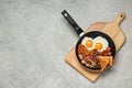 Frying pan with cooked traditional English breakfast on grey marble table, top view. Space for text Royalty Free Stock Photo