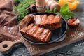 Frying pan with delicious ribs on wooden board