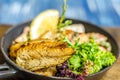 Frying pan with fish, lemon and herbs