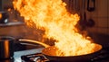 Frying pan with flames leaping from it in a dramatic kitchen accident showcasing fire hazard Royalty Free Stock Photo