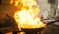 Frying pan with flames leaping from it in a dramatic kitchen accident showcasing fire hazard Royalty Free Stock Photo