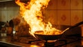 Frying pan with flames leaping from it in a dramatic kitchen accident showcasing fire hazard Royalty Free Stock Photo