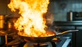 Frying pan with flames leaping from it in a dramatic kitchen accident showcasing fire hazard Royalty Free Stock Photo