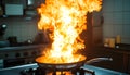 Frying pan with flames leaping from it in a dramatic kitchen accident showcasing fire hazard Royalty Free Stock Photo