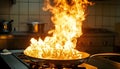Frying pan with flames leaping from it in a dramatic kitchen accident showcasing fire hazard Royalty Free Stock Photo
