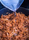 Frying pan with fried carrots. Water flowing. Toned