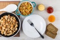 Frying pan with fried chicken meat, ratatouille, bread, sauces,