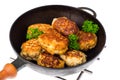 Frying pan with fried cutlets on white background