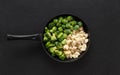 Frying pan with frozen vegetables on a black background. Cauliflower, broccoli, Brussels sprouts. Cabbage mix. Top view, flat lay Royalty Free Stock Photo