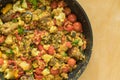 frying pan full of red lentils coocked with vegetables - red tomotoes, mangold , parsley, cauliflower, egg-plant, standing on a