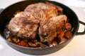 Frying pan with juicy roast beef and stewed vegetables on the table