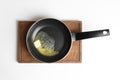 Frying pan with melting butter on board against white background Royalty Free Stock Photo