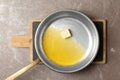 Frying pan with melting butter on grey background Royalty Free Stock Photo