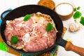 Frying pan with piece of raw meat with spices on white wooden table Royalty Free Stock Photo