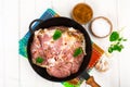 Frying pan with piece of raw meat with spices on white wooden table Royalty Free Stock Photo