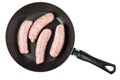 Frying pan with raw pork sausages isolated on white Royalty Free Stock Photo