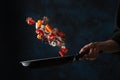 Frying pan with seafood and vegetables. Chef cooking meal. Healthy food. Creativity flying food. Dark background