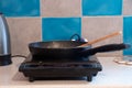 the frying pan is on a single induction electric stove on the kitchen table in the apartment, kitchen