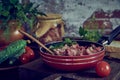 A frying pan with stewed meat seasoned with fresh herbs on a wooden countertop. Royalty Free Stock Photo