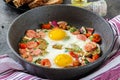 Frying pan with tasty cooked egg, sausages and vegetables on grey table Royalty Free Stock Photo
