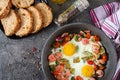 Frying pan with tasty cooked egg, sausages and vegetables on grey table Royalty Free Stock Photo