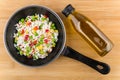 Frying pan with vegetable mix and bottle of vegetable oil Royalty Free Stock Photo