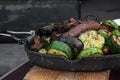 Frying pan with vegetables and sausages on the grill