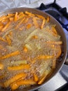 frying potato and sweet potato fries, frying pan full of hot oil, aluminum frying pan